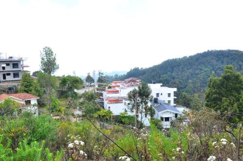 a group of buildings on a hill with trees at Redfox Villa - Kodaikanal in Kodaikānāl