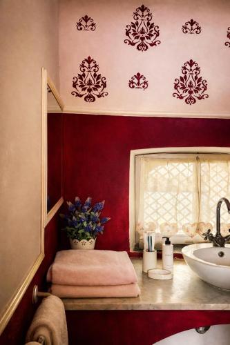 a bathroom with red walls and a sink and a window at Foresteria di Palazzo Picedi - Historic Rooms Sarzana in Sarzana