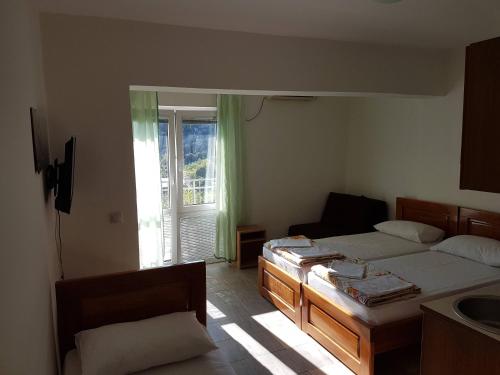 a bedroom with two twin beds and a window at Vila Stanisic in Čanj