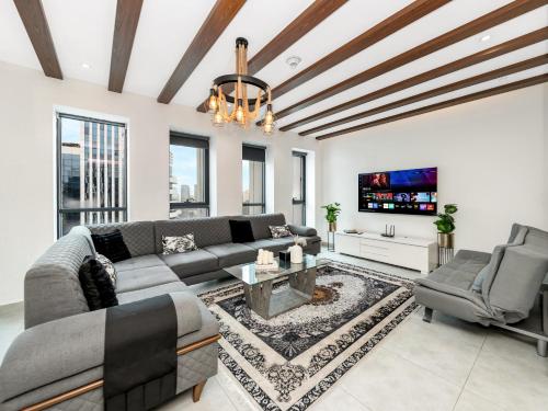 a living room with a couch and a tv at Luxury 3 Bedroom Sub Penthouse in Dubai