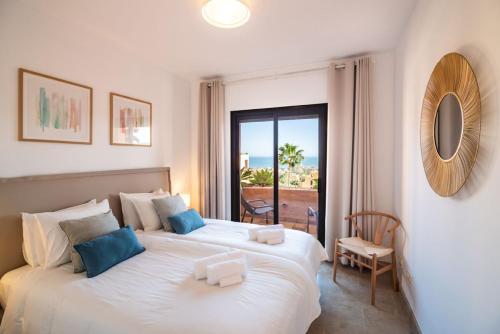 a bedroom with two beds with a view of the ocean at Seaview Apartment - COTO REAL Duquesa in Manilva