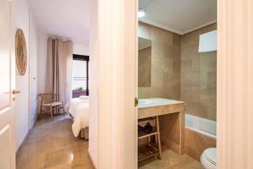 a bathroom with a bed and a sink and a toilet at Seaview Apartment - COTO REAL Duquesa in Manilva