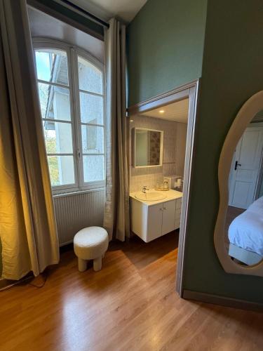 een badkamer met een bed, een wastafel en een spiegel bij Le Cozy in Saint-Jean-Poutge