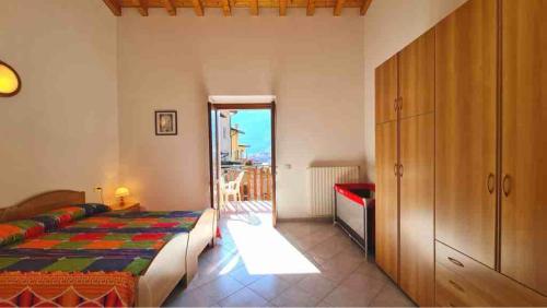 a bedroom with a bed and a door to a balcony at Appartamenti Bonaventura in Tignale