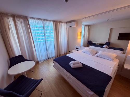a bedroom with a large bed with a large window at Sun Set Apartments in Batumi