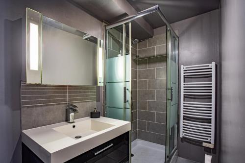 a bathroom with a sink and a glass shower at Maison de l'Orb in Cessenon