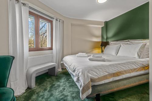 a bedroom with a bed with a green headboard and a window at Villa Octogon Câmpina in Câmpina