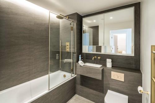 a bathroom with a shower and a toilet and a sink at Modern 3-Bedroom Apartment near Kings Cross & Coal Drops in London