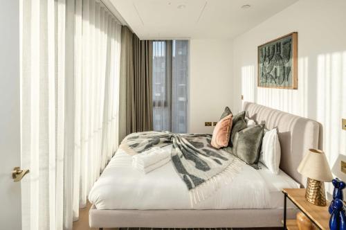 a bedroom with a large white bed with pillows at Modern 3-Bedroom Apartment near Kings Cross & Coal Drops in London