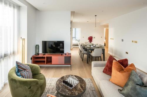 a living room with a couch and a table at Modern 3-Bedroom Apartment near Kings Cross & Coal Drops in London