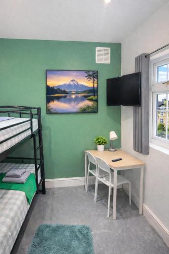 a bedroom with a desk and a bunk bed at 10 Minutes to Wembley Stadium Guest Rooms in London