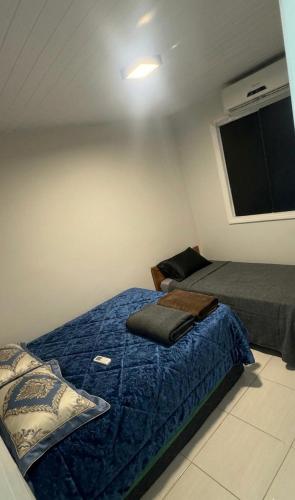 a bedroom with a bed with a blue comforter at Casa aconchegante com piscina e wi-fi rápido in Aracaju