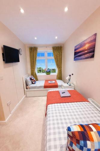 a bedroom with two beds and a window at 10 Minutes to Wembley Stadium Guest Rooms in London
