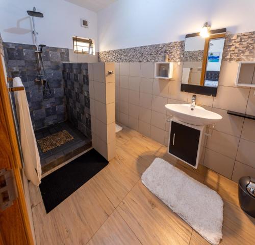 a bathroom with a sink and a shower at Villa Le Mahé, Mahébourg in Mahébourg