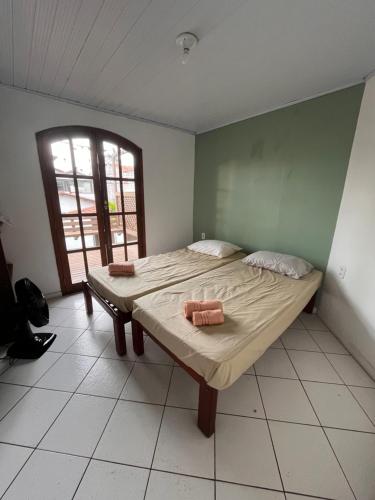a bedroom with a bed with two towels on it at Quarto em casa próx a rua das pedras in Búzios