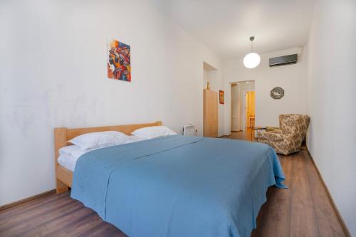 a bedroom with a blue bed and a chair at Avgarose in Itʼkhvisi