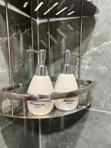 two toothbrushes on a metal shelf in a bathroom at Ruby Hotel in Nhơn Trạch