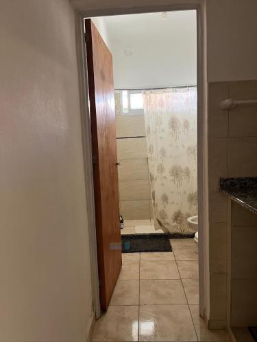 a bathroom with a toilet and a door with a shower at Casa 2 Habitaciones in Las Varillas