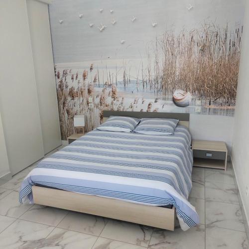 ein Schlafzimmer mit einem Bett und einem Gemälde an der Wand in der Unterkunft forgestudio in Saint-Bômer-les-Forges