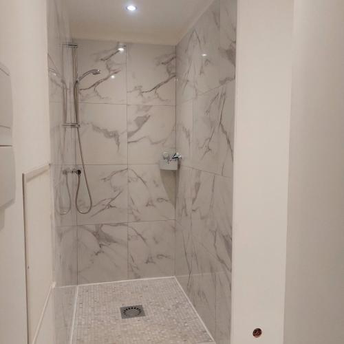 ein Badezimmer mit Dusche und Marmorfliesen in der Unterkunft forgestudio in Saint-Bômer-les-Forges