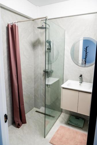 a bathroom with a glass shower and a sink at Piatra Studio in Piatra Neamţ