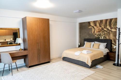 a bedroom with a bed and a desk and a mirror at Piatra Studio in Piatra Neamţ