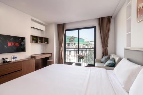 a hotel room with a large bed and a window at Luxe Paradise Suites - No34 Alley 260 Đội Cấn in Hanoi
