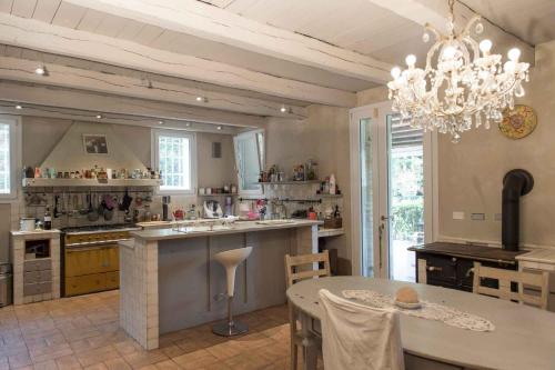 a large kitchen with a table and a chandelier at Casa Cardinala in Gambellaro