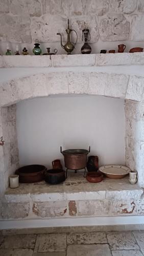 a brick fireplace with pots and pans on it at Casetta Wetto' in Monopoli