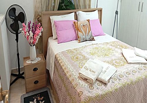 a bedroom with a bed with pink and purple pillows at Elias Home in Volos