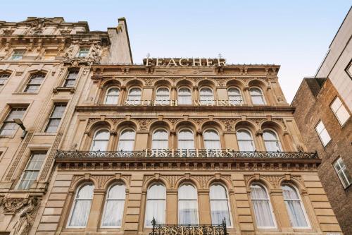 a tall building with a sign on top of it at VCity Suites at The Teacher in Glasgow