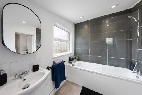 a bathroom with a white tub and a mirror at 3Bd Cosy Home-Wifi-Pool Table- Gilly Hideaway in Gillingham