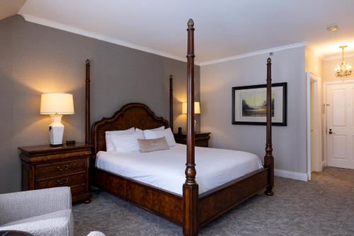 a bedroom with a four poster bed and a chair at Windermere House in Windermere