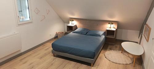 a bedroom with a bed and a table and two tables at Logement 2 - proche Le Mans in Aigné