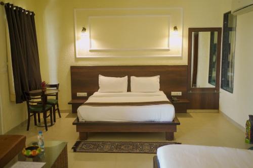 a bedroom with a bed and a table and a chair at Rani Palace Hotel And Resort in Kishangarh