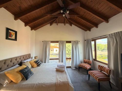 a bedroom with a large bed with a ceiling fan at Estancia de Cafayate Wayra Huasi in Cafayate