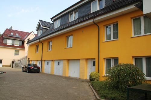 a yellow building with a car parked next to it at Hotel Neuses in Cuxhaven