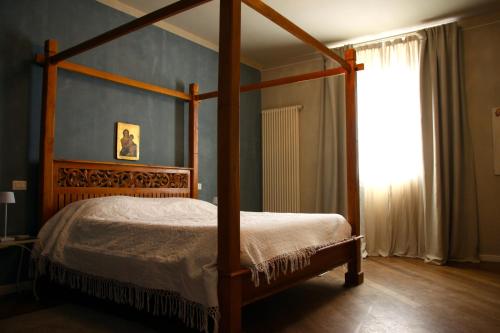 a bedroom with a canopy bed and a window at Casa Cardinala in Gambellaro