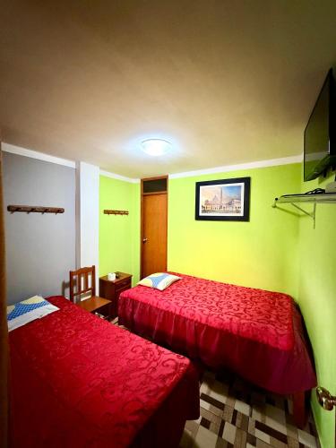 two beds in a room with green and red at HOSTAL GRAU in Churín