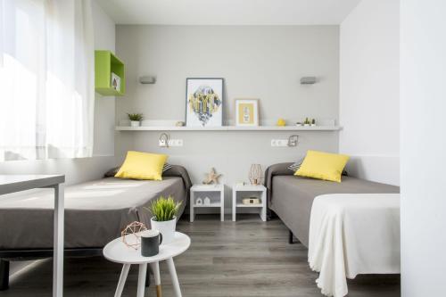 uma sala de estar com duas camas e uma mesa em Residencia Universitaria Barcelona Diagonal em Barcelona