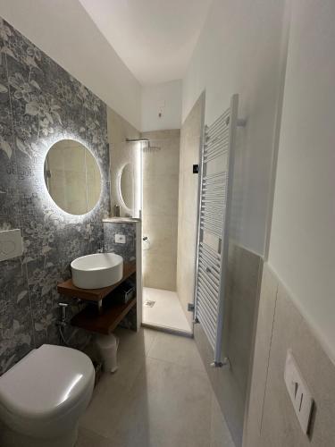 a bathroom with a toilet and a sink and a shower at Piazza Sant'Agostino Rooms in Bagnoregio