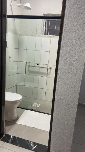 a bathroom with a glass shower with a toilet at HotelItaveraMS in Campo Grande