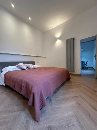 a bedroom with a large bed with a red blanket at Piazza Sant'Agostino Rooms in Bagnoregio