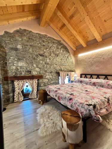 a bedroom with a bed and a stone wall at La Casetta in Oyace