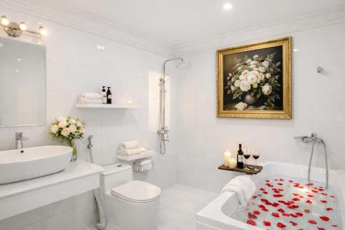 a white bathroom with a sink and a bath tub at Villa FLC Sầm Sơn Đức Anh in Sầm Sơn