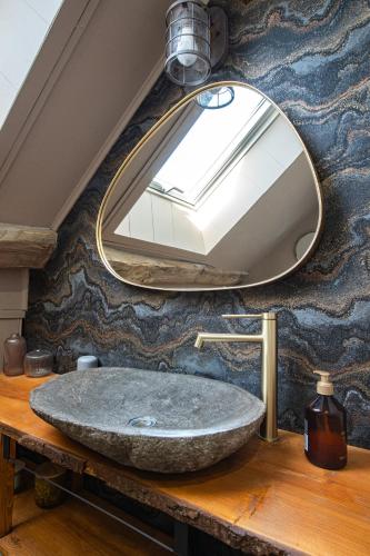 a bathroom sink with a large mirror on a wall at Domaine Kaet in Ratenelle