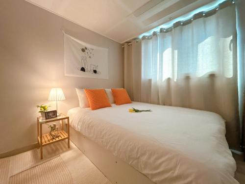 ein Schlafzimmer mit einem weißen Bett und einem Fenster in der Unterkunft Gate 303 in Seoul