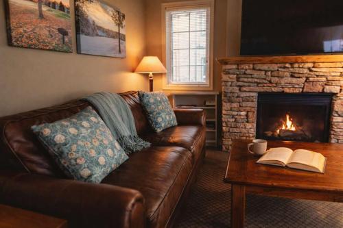 a living room with a leather couch and a fireplace at Picturesque Condo perfect for Golf, Families, Pools and Lake vacation in Bellaire