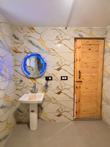 a bathroom with a sink and a stone wall at Dream River Resort in Batakūt