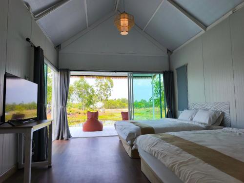 a bedroom with two beds and a large window at Secret Terrace Pool Villa Rayong in Ban Bua Phut
